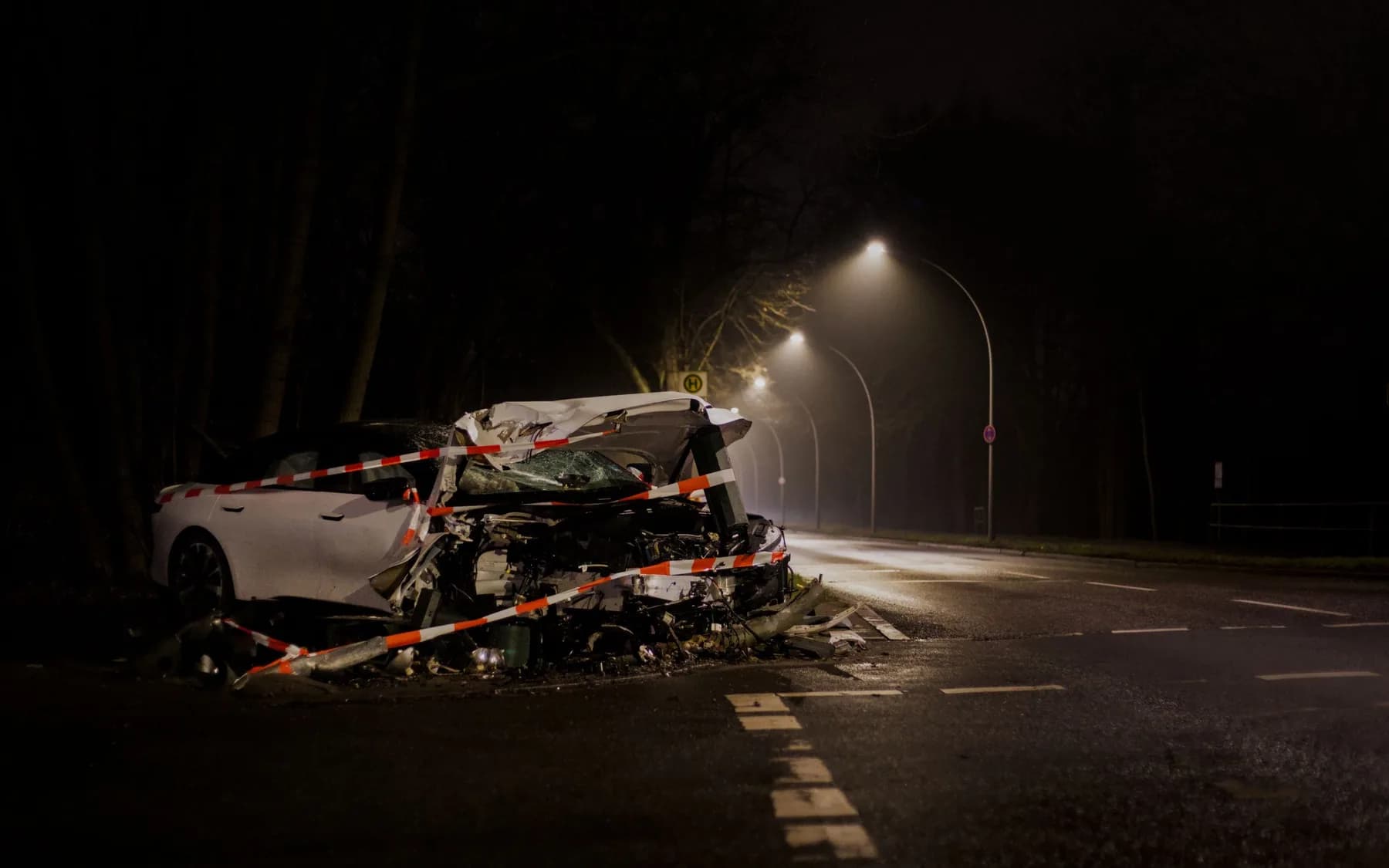 Un auto destrozado acordonado en una calle de noche