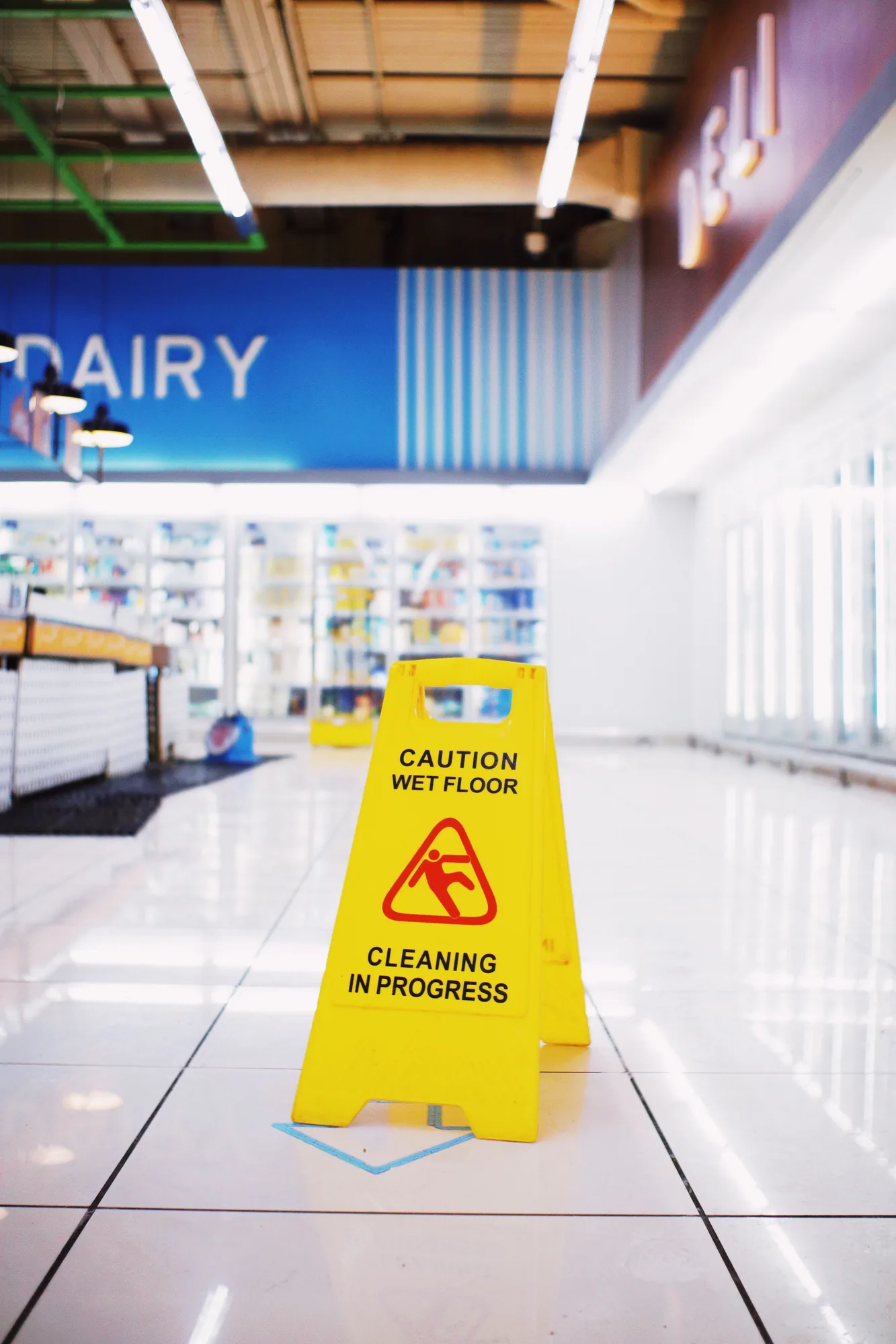 A caution wet floor sign in a supermarket aisle